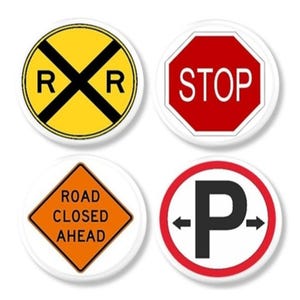 May include: Four white-backed buttons displaying road signs. Includes a yellow railway crossing sign, a red stop sign, an orange road closed ahead sign, and a parking sign with arrows.