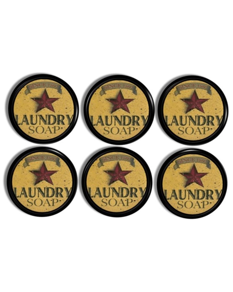 May include: A set of six circular black-rimmed signs with a distressed yellow background. Each sign features a dark red star, the text "SINCE 1892" on a banner, and the words "LAUNDRY SOAP" printed in black, bold, capital letters.