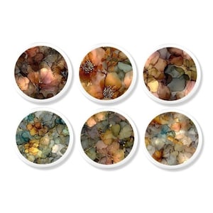 May include: A set of six circular coasters featuring abstract floral patterns in shades of brown, orange, teal, and cream. Each coaster has a white border and displays a unique, fluid ink-style design with layered petals and organic shapes.