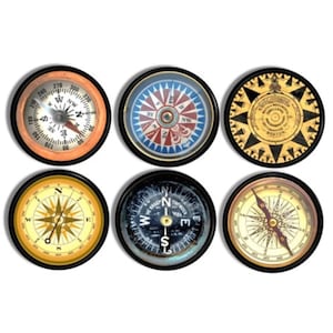 May include: Set of six decorative compass wall plaques with various designs. Each plaque features a compass with a black frame and a white background. The compasses have different designs, including a traditional compass with a red needle, a compass with a star design, and a compass with a nautical theme.