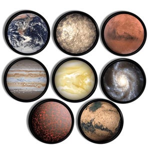 May include: Set of seven round, framed images of planets and a galaxy. The images are in black frames and feature a variety of colors, including blue, brown, red, and white.