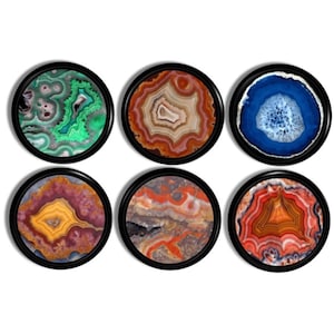 May include: Six round coasters with black frames, each featuring a unique agate stone design. The coasters display a variety of colors, including green, brown, blue, purple, gray, and orange. These decorative coasters are perfect for adding a natural touch to any home.