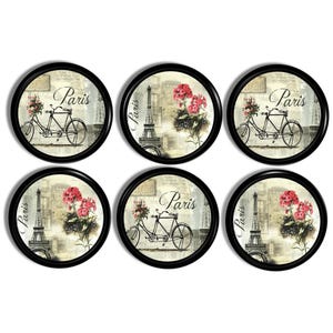 May include: Six circular coasters with black borders, each displaying a vintage Parisian design. The designs include the Eiffel Tower, bicycles, and floral arrangements, with the word "Paris" in elegant script.