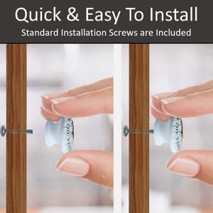 Op de afbeelding: Close-up van een witte keramische knop met een zwart-wit ontwerp dat in een houten deur wordt geschroefd. De knop wordt vastgehouden door een hand. De tekst "Quick & Easy To Install" en "Standard Installation Screws are Included" is zichtbaar bovenaan de afbeelding.