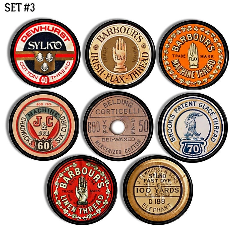 Op de afbeelding: Set van zes vintage garenklossen met verschillende kleuren en ontwerpen. De klossen hebben tekst zoals "Sylko", "Barbour's", "Belding Corticelli", "Brooks Patent Glace Thread" en "Dewhurst & Sons".