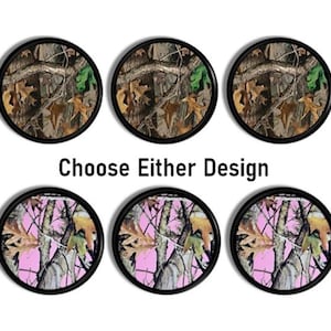 May include: Six circular coasters with black rims, arranged in two rows of three. The top row features a brown and green forest camouflage pattern, while the bottom row displays a pink and brown forest camouflage pattern. Text reads Choose Either Design.