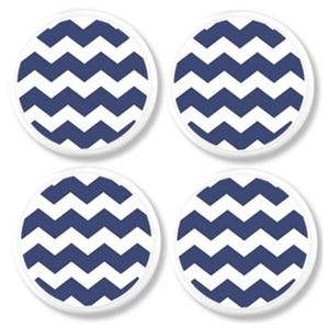 May include: Four round coasters with a white border and a navy blue and white chevron pattern. The coasters are arranged in a square formation against a white background. These coasters are suitable for home decor.