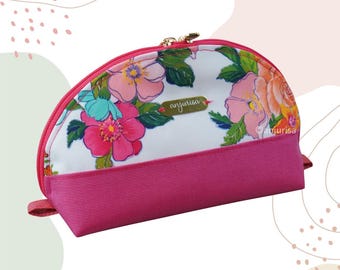 May include: A pink and white floral print makeup bag with a zipper closure. The bag has a pink fabric lining and the words "anjurisa" are printed on the front.