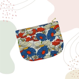 May include: A zippered pouch featuring a repeating floral pattern of red, blue, and cream-colored daisies on a white background. The fabric accessory has a gold-toned metal zipper pull and includes the text danjurisa printed on the front surface.