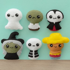 May include: Six felt Halloween character ornaments. A ghost, a zombie, a vampire, a witch, a skeleton, and a cowboy.