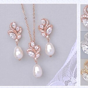 May include: A rose gold bridal necklace and earrings set with pear-shaped crystals and pearl drops. The set is available in rose gold, silver, and gold.