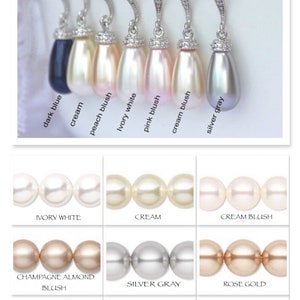 May include: A selection of pearl earrings in various colors, including ivory white, cream, cream blush, champagne almond blush, silver gray, rose gold, peach blush, and black. The earrings are displayed on a white background.