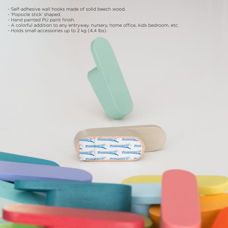 May include: Self-adhesive wall hooks in a 'popsicle stick' shape, made from solid beech wood with a hand-painted finish. These colourful hooks can hold small accessories up to 2 kg and are suitable for entryways or nurseries.
