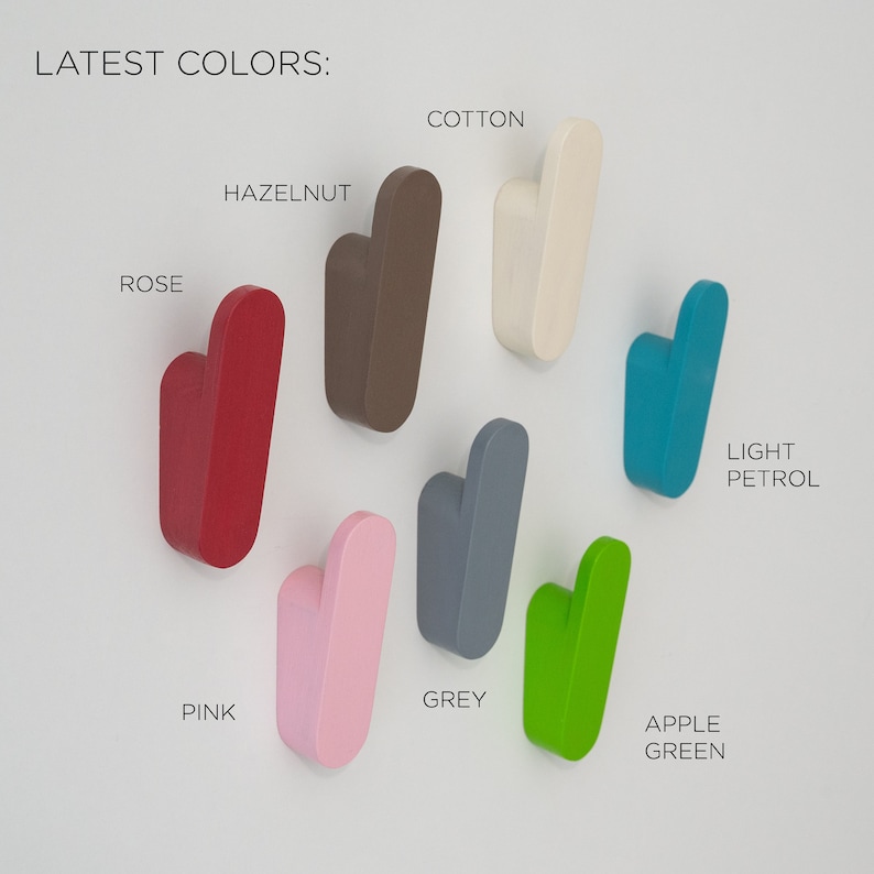 May include: A selection of wooden wall hooks in colours such as rose, hazelnut, cotton, light petrol, apple green, grey, and pink. The text "LATEST COLORS:" is displayed at the top of the image.