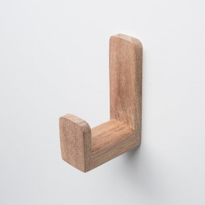 May include: A wooden wall hook with a simple design. The hook is made of natural wood and has a light brown color.