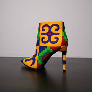 May include: A yellow, blue, green, and red patterned ankle boot with a high heel.
