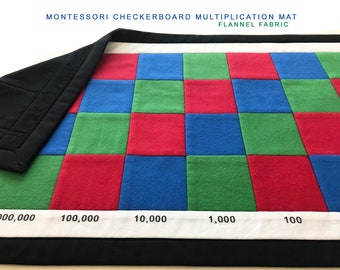 May include: A Montessori checkerboard multiplication mat made of flannel fabric. The mat is divided into squares of red, blue, and green fabric. The squares are labeled with numbers: 100,000, 10,000, 1,000, and 100.