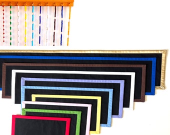 May include: A set of ten black felt boards with different colored borders. The boards are arranged in a fan shape, with the largest board at the top and the smallest board at the bottom. The colors of the borders are gold, blue, brown, white, light blue, yellow, pink, green, and red.