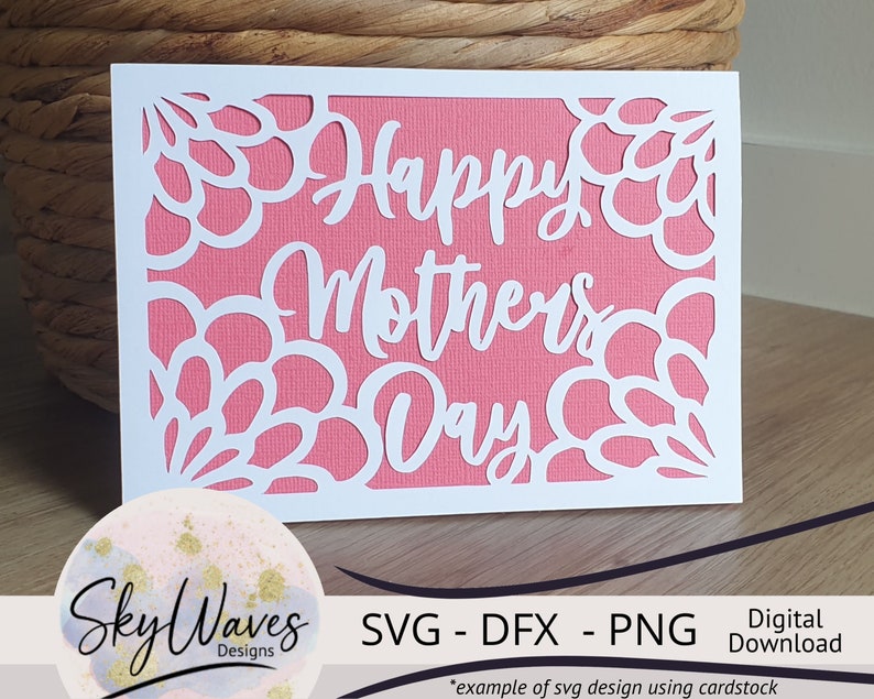May include: White cardstock cut-out design with a pink background. The design features a floral border and the text "Happy Mother's Day".