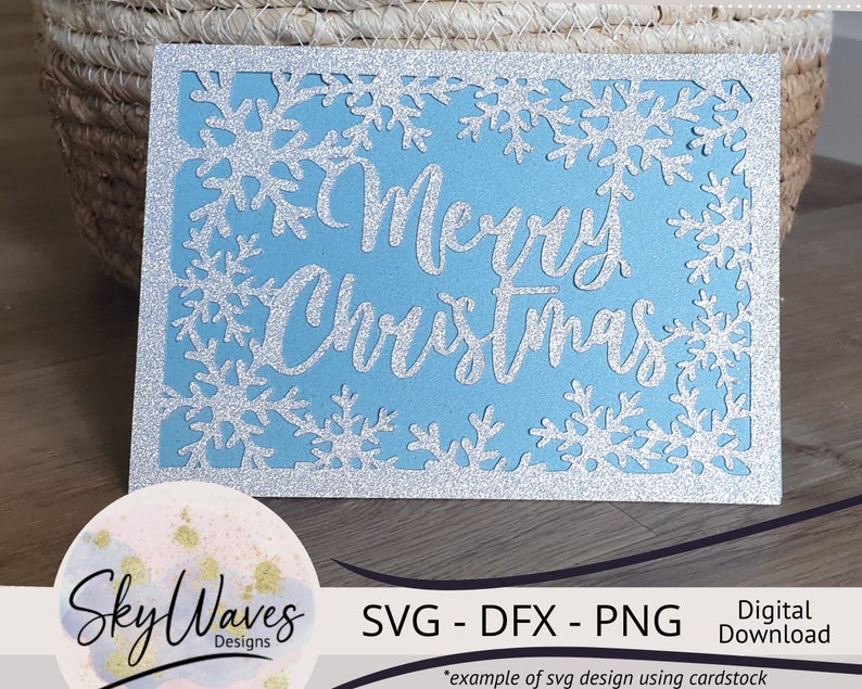K&ouml;nnte beinhalten: Eine hellblaue Weihnachtskarte mit silbernem Glitzerrahmen und Schneeflocken-Ausschnitten. Die Worte "Merry Christmas" sind in silberner Schrift. Digitaler Download.