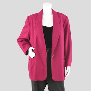 May include: A magenta blazer with a classic notched collar and two front pockets. The blazer has a single gold button closure and is displayed on a mannequin. The mannequin is wearing a black top and black pants.