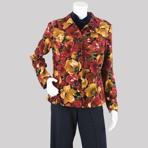 May include: A floral print jacket with a button-up front, featuring a vibrant pattern of red, yellow, and brown flowers on a black background. The jacket has long sleeves and a collared neckline. The jacket is displayed on a mannequin.