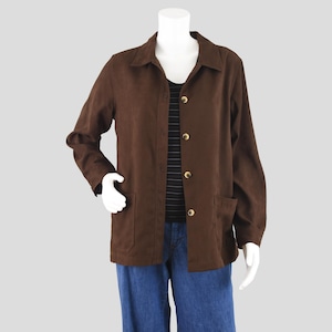 May include: A brown jacket with a collared neckline, long sleeves, and two front pockets. The jacket has gold-colored buttons and is worn over a black and white striped shirt and blue jeans.