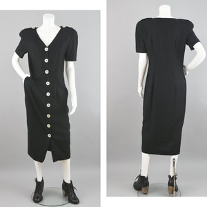 May include: A black midi dress with a button-up front and short sleeves. The dress has a v-neckline and a fitted silhouette.