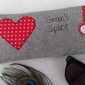Personalised heart applique glasses case.  Spectacles or sunglasses pouch with choice of red dot or pink floral heart on linen or grey wool. coordinating ribbon and button fastening.  unique handmade customisable anniversary valentines gift