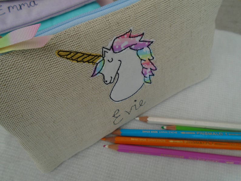 Unicorn motif personalised pencil case or cosmetic bag.  Pen or makeup pouch with choice of colour and coordinating lining.  Fastened with a zip and rainbow ribbon pull.  Ideal girls back to school gift