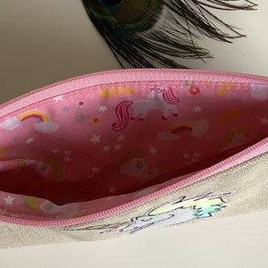 Unicorn motif personalised pencil case or cosmetic bag.  Pen or makeup pouch with choice of colour and coordinating lining.  Fastened with a zip and rainbow ribbon pull.  Ideal girls back to school gift