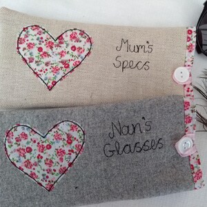 Personalised heart applique glasses case.  Spectacles or sunglasses pouch with choice of red dot or pink floral heart on linen or grey wool. coordinating ribbon and button fastening.  unique handmade customisable anniversary valentines gift