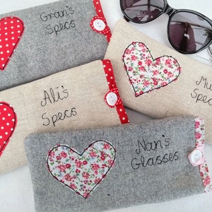Personalised heart applique glasses case.  Spectacles or sunglasses pouch with choice of red dot or pink floral heart on linen or grey wool. coordinating ribbon and button fastening.  unique handmade customisable anniversary valentines gift