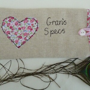 Personalised heart applique glasses case.  Spectacles or sunglasses pouch with choice of red dot or pink floral heart on linen or grey wool. coordinating ribbon and button fastening.  unique handmade customisable anniversary valentines gift