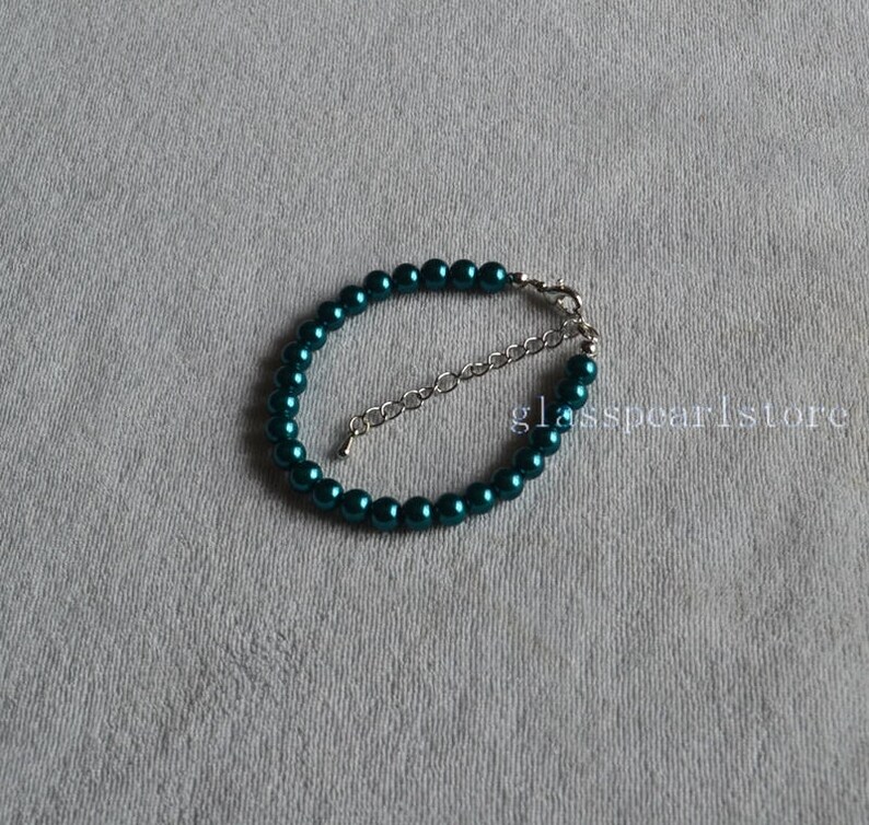 May include: A teal blue pearl bracelet with a silver clasp.