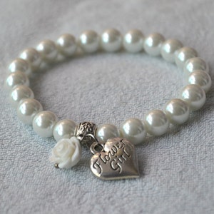 May include: White pearl bracelet with a silver heart charm that says "Flower Girl".