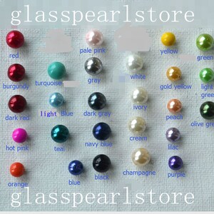 May include: Assortment of glass beads in various colors, including red, burgundy, dark red, hot pink, orange, turquoise, light blue, teal, navy blue, blue, black, pale pink, gray, dark gray, white, ivory, cream, champagne, gold yellow, light green, yellow, green, peach, lilac, and olive green. The beads are arranged in rows on a white surface. The text "glasspearlstore" appears at the top and bottom of the image.
