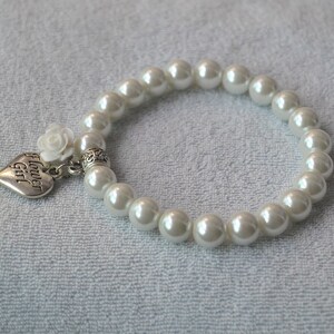 May include: White pearl bracelet with a silver heart charm that says "Flower Girl". The charm also has a small white flower attached.