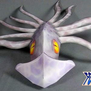 Puede incluir: Un modelo de papel de un calamar morado y blanco con ojos amarillos. El calamar tiene ocho tentáculos y una boca en forma de pico. El modelo está hecho de papel y está doblado en una forma tridimensional. El modelo está sobre un fondo gris.  >>FOLDATICK.COM