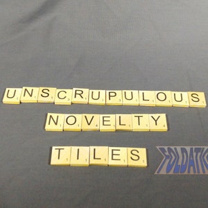 May include: The word "UNSCRUPULOUS" spelled out with yellow letter tiles, followed by the word "NOVELTY" and then the word "TILES".