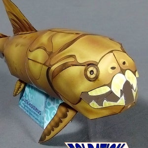 May include: A papercraft model of a prehistoric fish with a large head and sharp teeth. The model is painted in shades of brown and yellow, with details like eyes and gills. The model is standing on a base with the text "FOLDATORK.COM" printed on it.