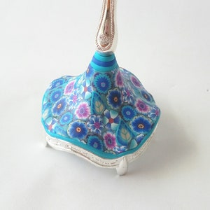 May include: A silver base with a blue and white floral design. The base has a decorative top with a silver stem.