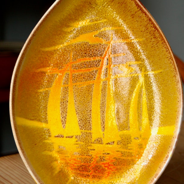 A Poole Pottery deep plate from the Aegean series decorated with sailboats at sunset.