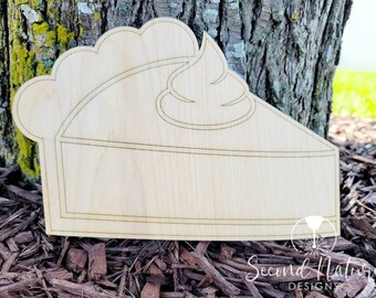 May include: A wooden cutout of a pie slice with a swirl of whipped cream on top. The cutout is unfinished and ready to be painted or decorated.