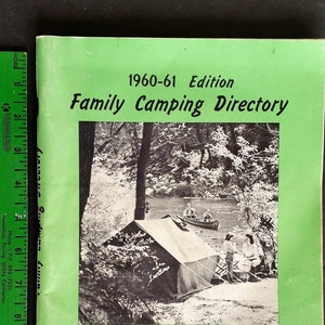 May include: A bright green 1960-61 Family Camping Directory book with a black and white cover photo of a tent and canoe. A green ruler is placed along the left side, showing the book is approximately 11 inches tall and 8.5 inches wide.