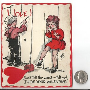 May include: Vintage Valentine's Day card with a red border. The illustration shows a boy writing "I love!" on a wooden fence while a girl reacts. A red heart and text "Don't tell the world - tell me! I'll be your Valentine!" are also present.