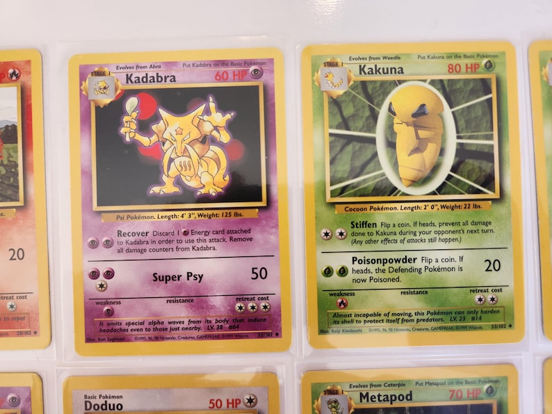 May include: Two vintage Pok&eacute;mon trading cards. The first card features Kadabra, a yellow creature with a spoon, and the second card features Kakuna, a yellow cocoon-like Pok&eacute;mon. Both cards are in protective sleeves.
