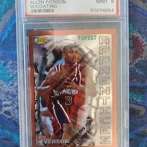 May include: A 1996 Finest Allen Iverson basketball card, graded Mint 9 by PSA, encased in a protective holder. The card features a photo of Allen Iverson in his Philadelphia 76ers uniform, with the word "Finest" visible.