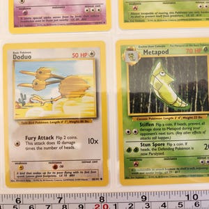 May include: Two Pok&eacute;mon trading cards, Doduo and Metapod, are displayed. Doduo, a twin bird, is depicted in brown and tan. Metapod, a cocoon Pok&eacute;mon, is shown in green. The cards are in protective sleeves.