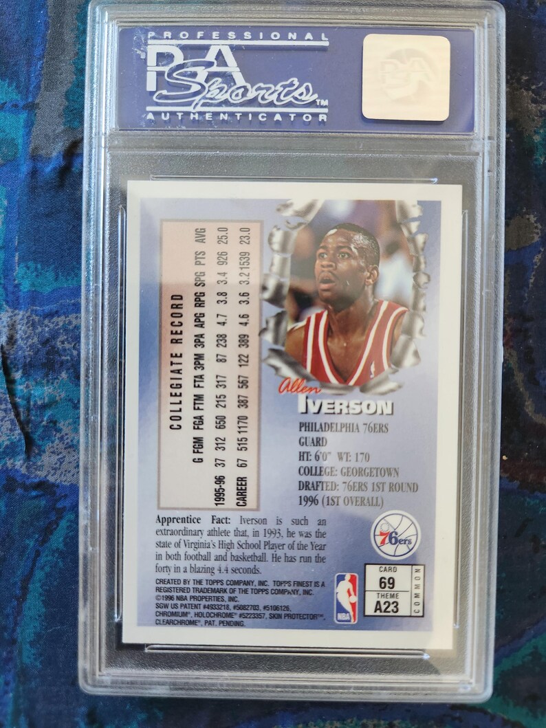 May include: A professionally graded Allen Iverson basketball card, encapsulated in a clear plastic case. The card features a photo of Iverson in a 76ers uniform, along with his collegiate record and other details. The card is labeled "69" and "A23".